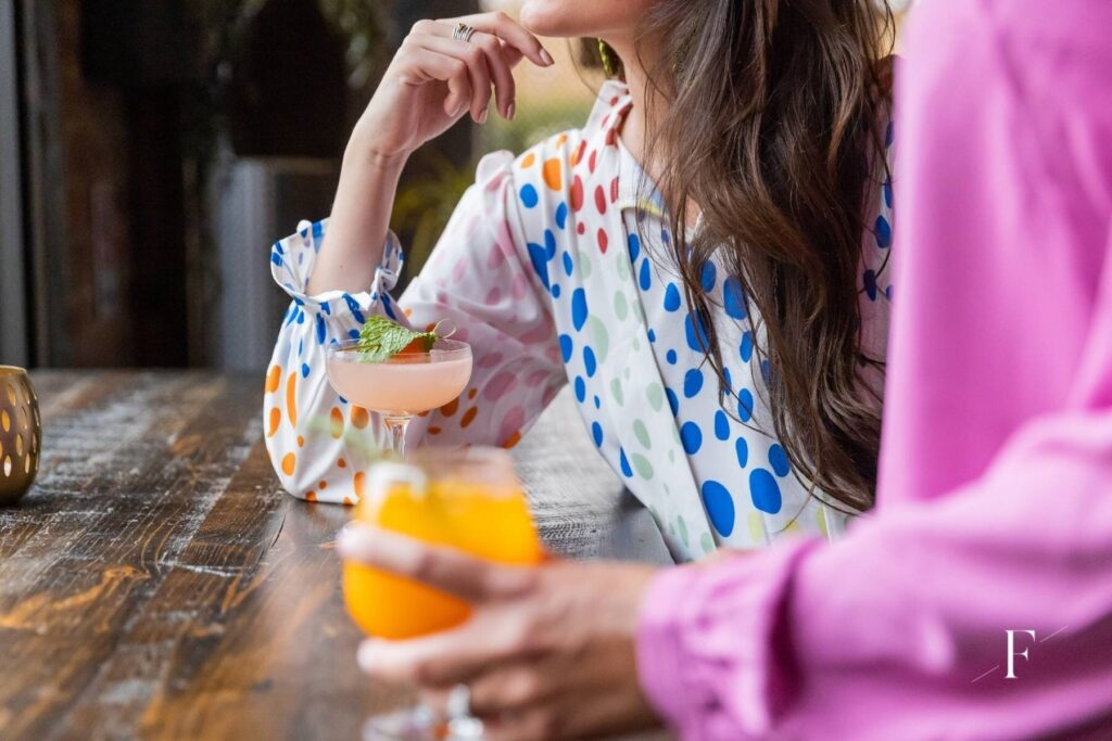 women sitting at a bar showing off the clothes | lifestyle imagery for an online boutique used for social media marketing and creating a cohesive brand