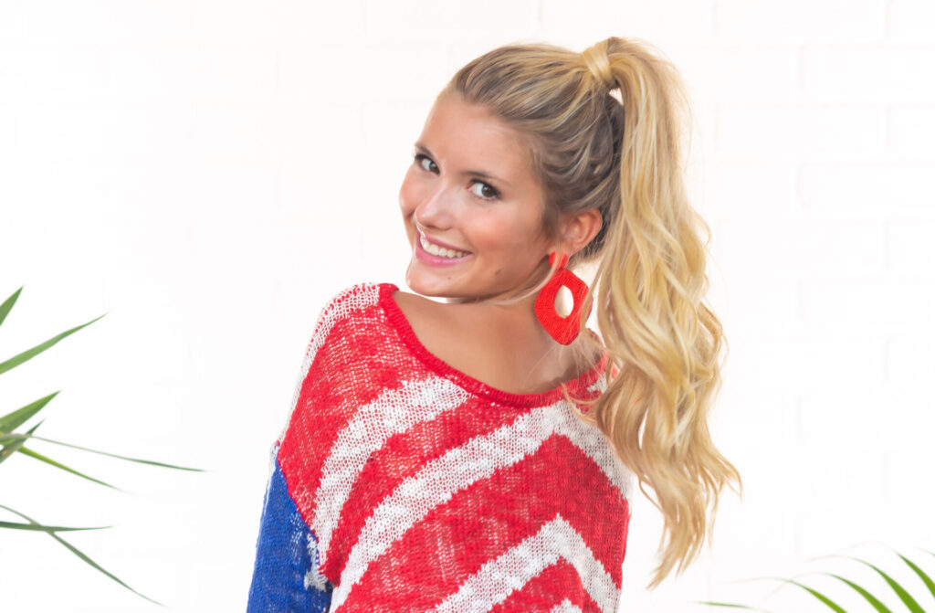 woman wearing an american flag sweater looking over her shoulder