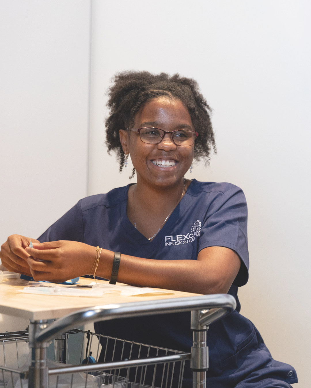 woman nurse sitting at table smiling off camera