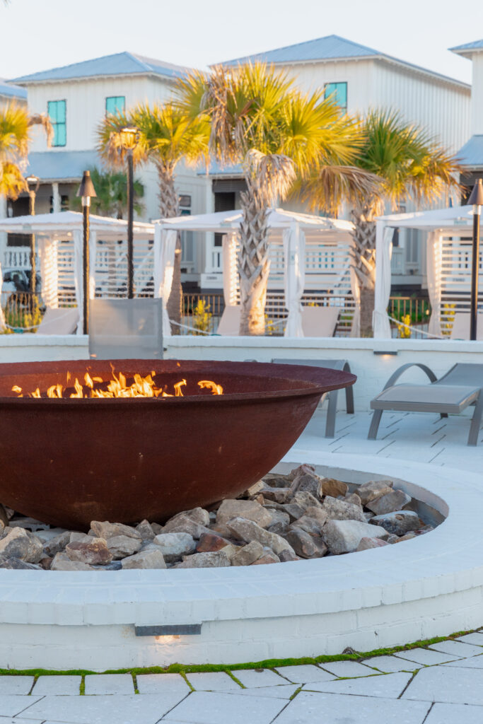 Fire pit over stones with palm trees in the background